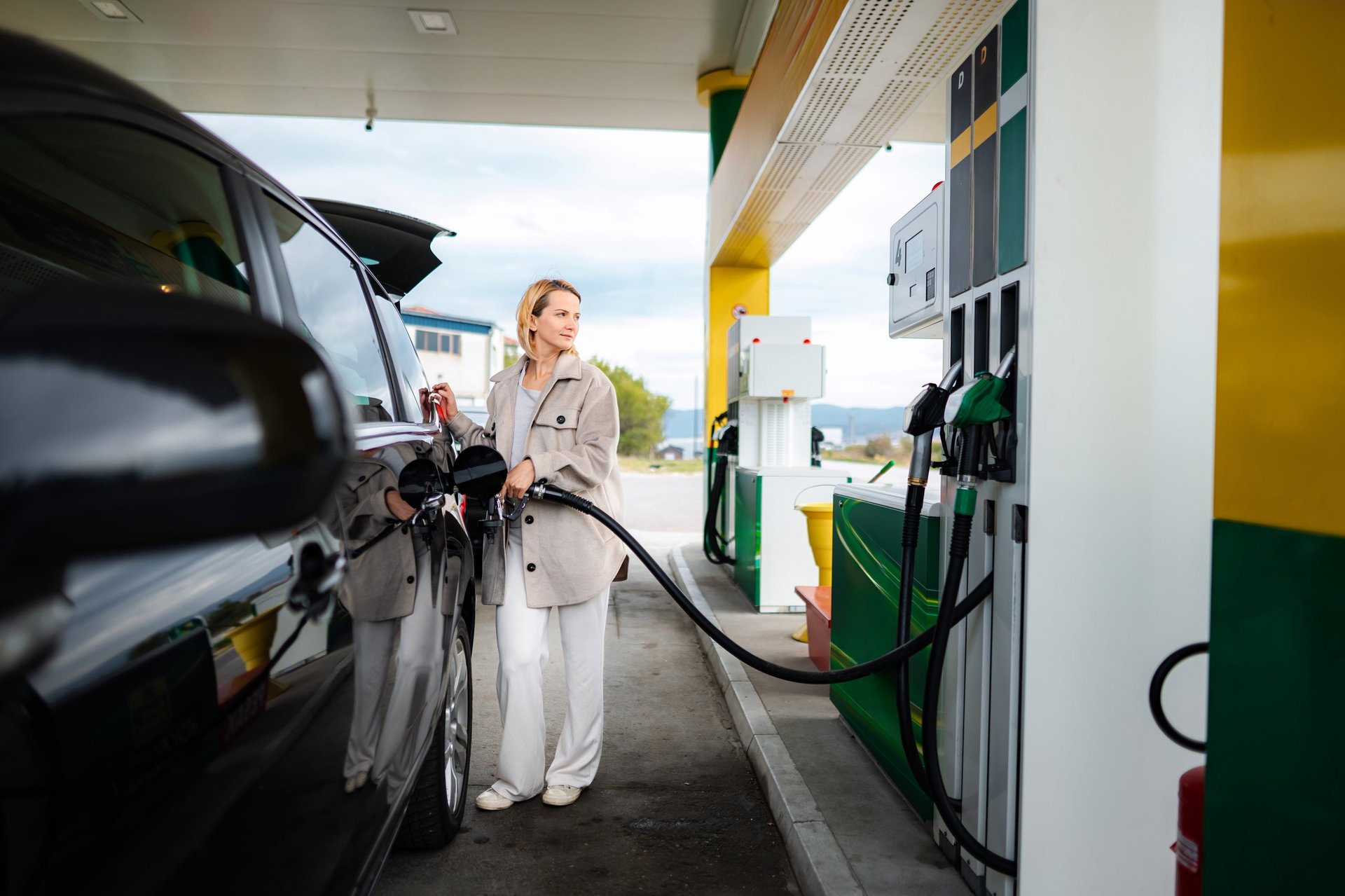 Vrouw tankt benzine bij tankstation